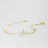 Gold bracelet with a small triangle charm on a light gray background