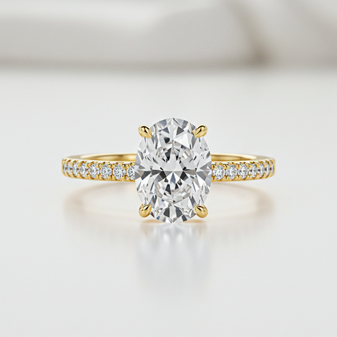 Gold ring with a large diamond and smaller diamonds on the band against a light background