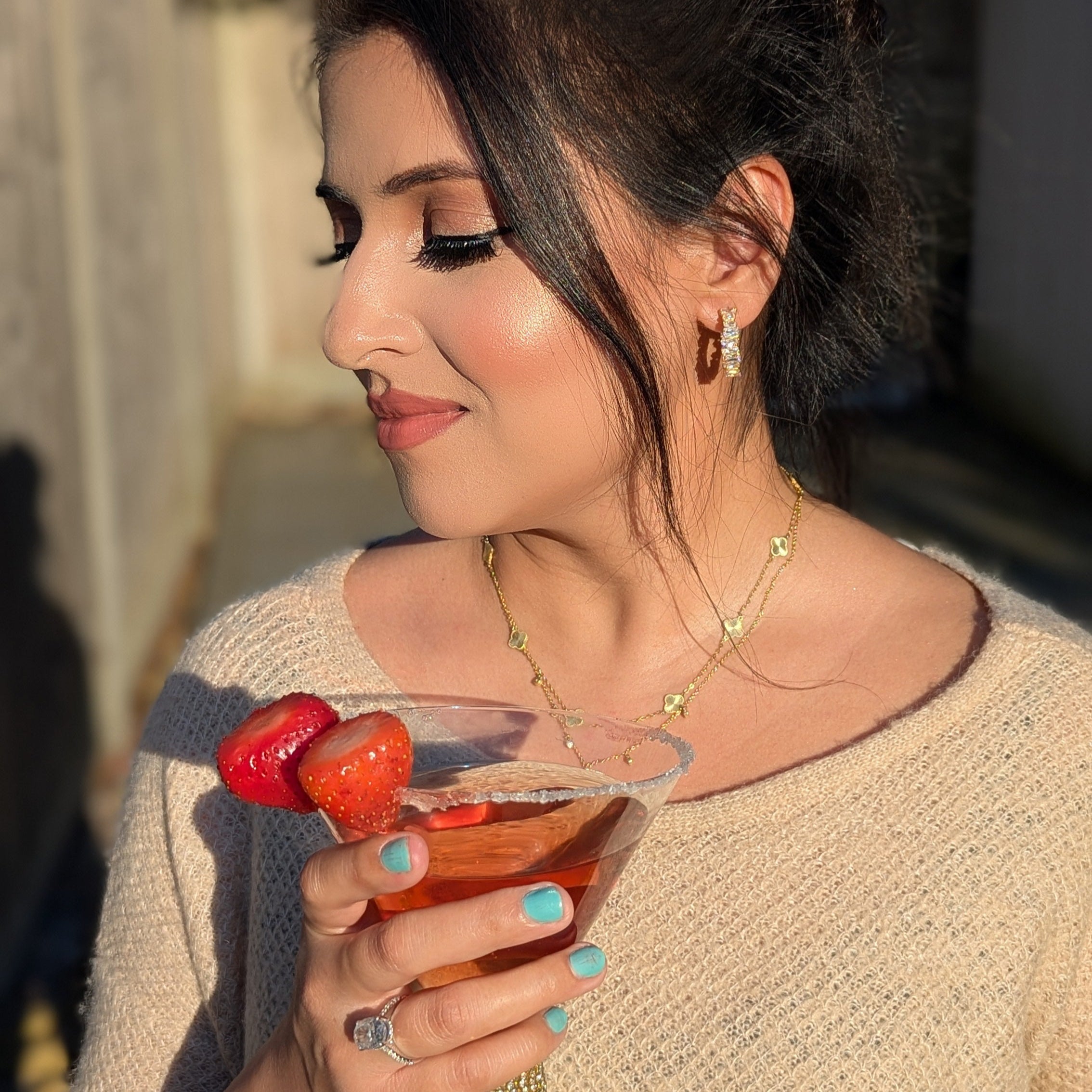 Woman holding a drink with strawberries outdoors