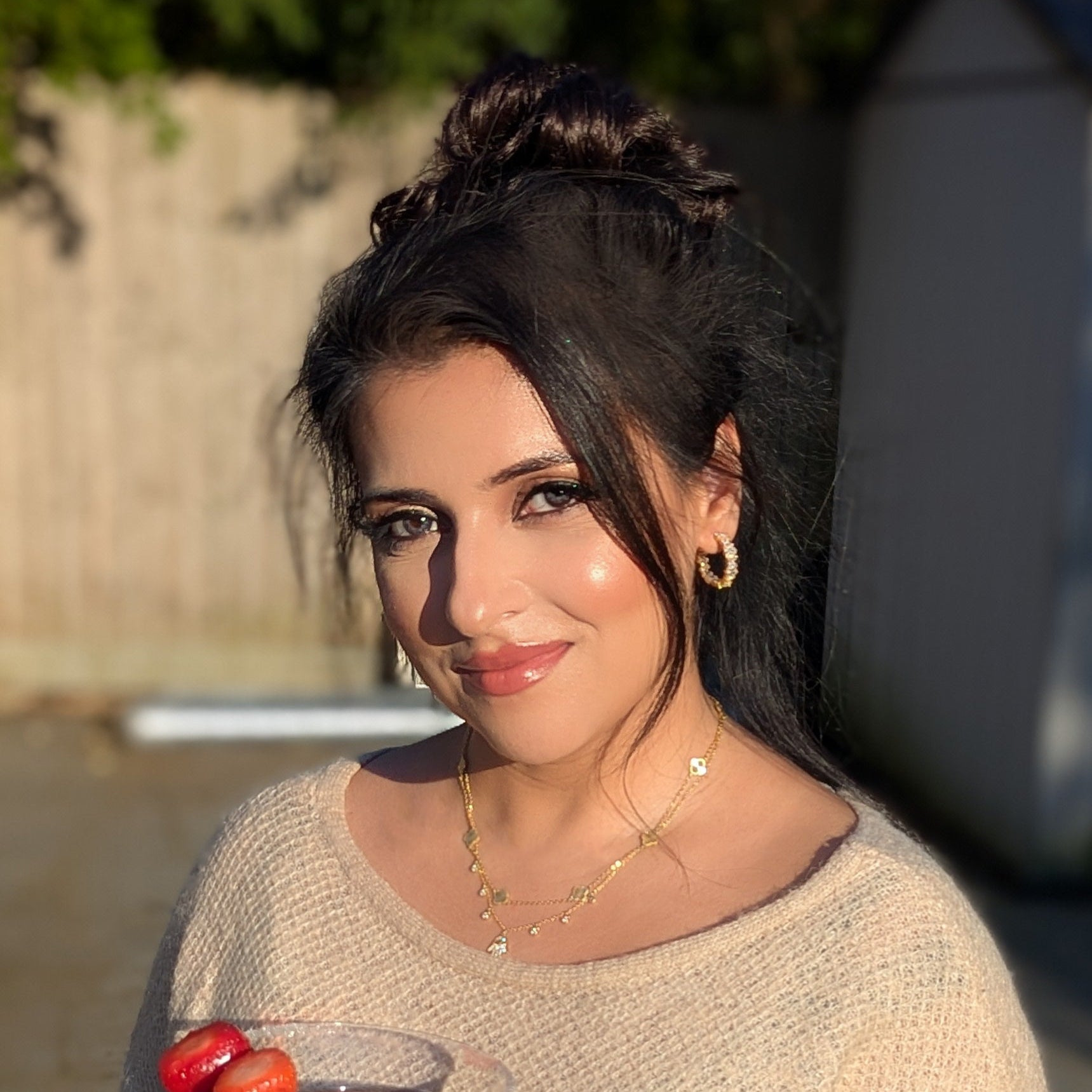 Woman holding a drink outdoors with a blurred background