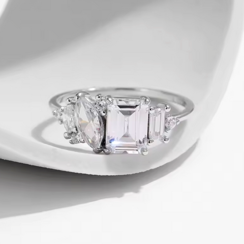 Diamond ring with three clear gemstones on a white background