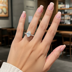 Hand wearing a diamond ring with a blurred cafe background