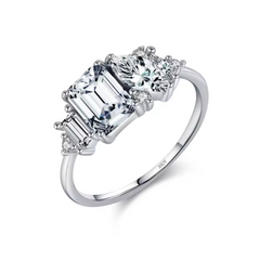 Silver ring with three diamond stones on a white background